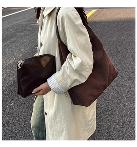 Detail of minimalist dark brown suede tote and matching leather pouch for daily styling