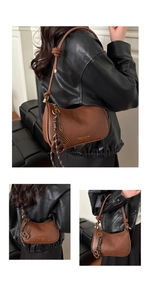 Detail view of a brown vintage crescent leather shoulder bag with decorative knot and strap