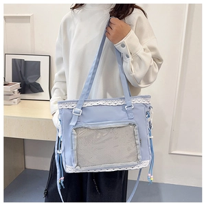 Close-up of light blue crossbody bag with white lace trim and mesh front pocket detail