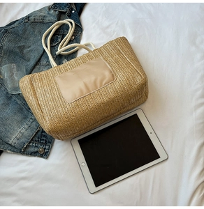Close-up of large woven straw tote bag with cotton rope handles and interior storage