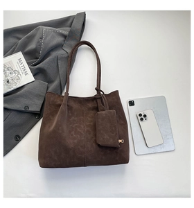 Detailed close-up of dark brown suede tote bag with matching zip pouch and daily essentials