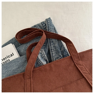 Detailed macro view of the caramel corduroy tote bag featuring thick ribbed fabric texture
