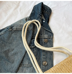Detailed close-up of retro washed blue denim jacket fabric and engraved metal buttons