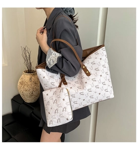 Detail of printed tote bag with swan pattern and matching pouch on a fashion model