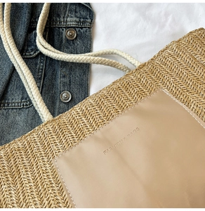Detail of woven straw tote bag featuring a beige PU leather pocket and cotton rope handles