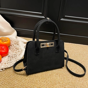 Vintage matte black top-handle bag with gold hardware and versatile shoulder strap