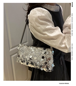 Close-up of sparkling silver sequins and metal shoulder strap on a chic underarm bag