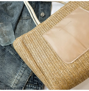 Detailed macro view of woven tote bag texture with fashion label and thick rope handles