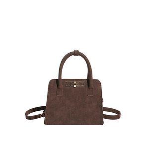 Vintage dark brown matte handbag with gold rotating lock and top handle on white background