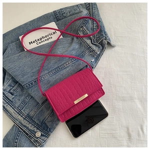 Fuchsia crocodile embossed square bag with gold metal trim and adjustable strap