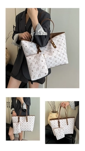 Close-up of printed white tote bag with matching pouch and brown leather handles