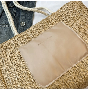 Detail of woven straw tote bag texture with khaki leather pocket and cotton rope handle