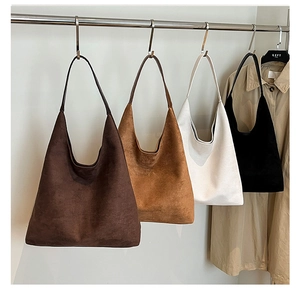 Detail view of large minimalist matte suede tote bags in brown, white and black colors