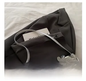 Detail view of silver sequins handbag with metallic reflective texture and thin handle
