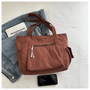 Détail du sac fourre-tout en velours côtelé marron montrant la poche cargo latérale
