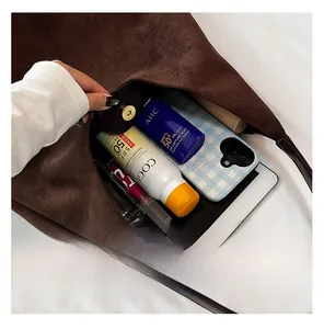 Interior view showing the large capacity of the brown suede tote bag with daily items