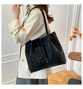 Detailed side view of a large black matte tote bag with matching hanging coin purse
