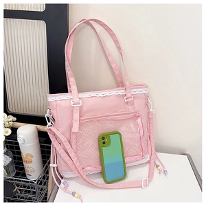 Detailed pink nylon tote bag featuring delicate white lace trim and mesh pocket design