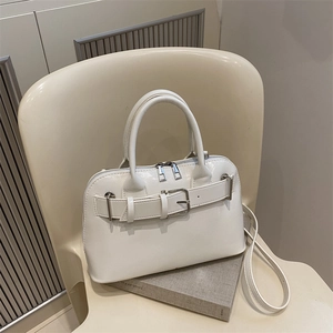 Chic white PU leather handbag with buckle detail, featuring top handles and long shoulder strap