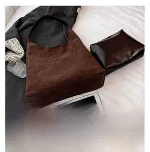 Flat lay of brown vintage frosted leather tote bag with a black inner pouch and tablet