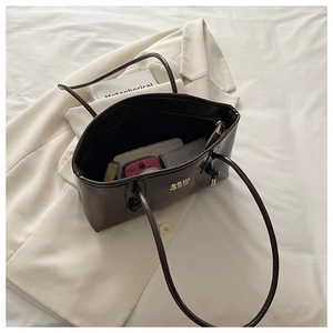 Top-down view of a spacious brown leather tote bag with diverse daily items inside