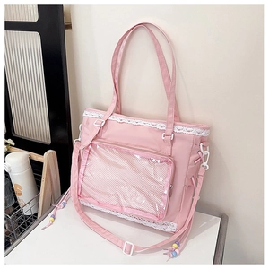 Pink canvas ita bag featuring a large clear window and white lace trim detail