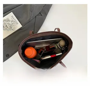 Detailed interior of large brown tote bag showing capacity for tablet and daily items