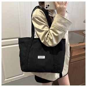 Mirror selfie showing the large black corduroy tote bag with Fashion Instinct label