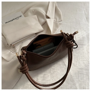 Detailed interior view of a dark brown faux leather bag with zipper and golden hardware