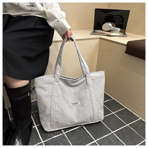 Detail of grey corduroy tote bag showing side view and fashion instinct fabric label
