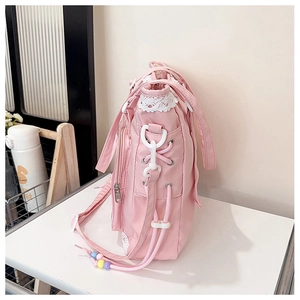 Pink canvas tote bag featuring white lace edges, metal eyelets, and colorful bead charms
