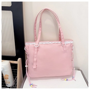 Close-up of pink tote bag featuring white lace trim and colorful beaded drawstring details