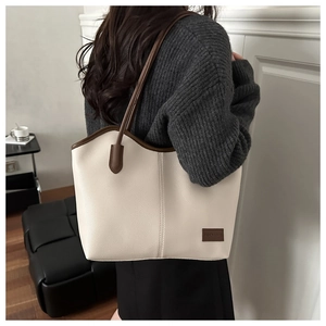 Close-up of beige tote bag showing lychee grain leather and fashion leather label detail