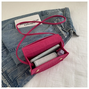 Internal view of rose red crocodile pattern mini bag showing storage for phone and lipstick