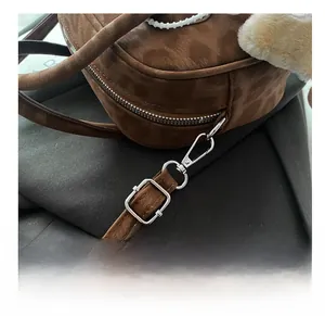 Detailed macro view of high-quality silver metal hook and suede texture on a leopard bag