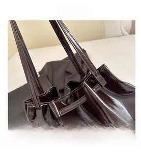 Close-up of polished oil wax leather texture and strap stitching on tote bag