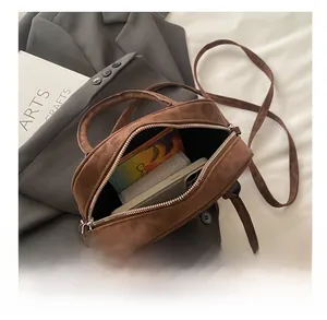 Detail view of the spacious interior of a brown suede crossbody bag for daily essentials
