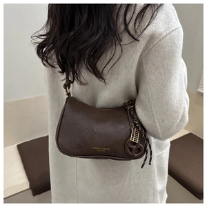 Detail of vintage dark brown leather crossbody bag with golden abacus charm and text