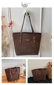 Detail view of coffee brown frosted tote bag with gold rivets and leather straps