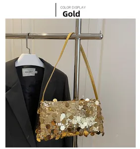 Detail of shimmering gold sequin baguette bag with metallic texture and thin strap