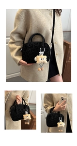 Detail of black leopard print Boston bag with fuzzy charm and detachable strap