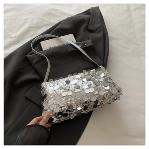 Detailed close-up of a silver sequin shoulder bag with reflective metallic finish and chain