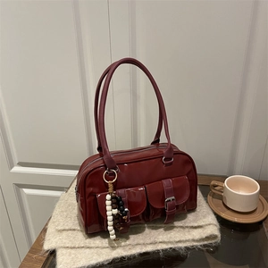 Retro burgundy patent leather Boston bag with silver buckles and pearl charm on a scarf