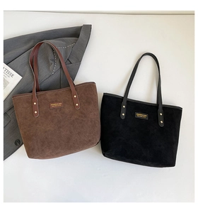 Detail of minimalist matte tote bags in brown and black with leather logo patch