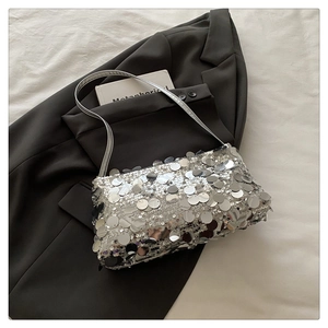 Detail of silver sequin shoulder bag showing reflective metallic textures and chic chain strap