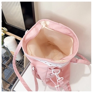 Detail of pink canvas bucket bag showing lace trim and secure zipper closure