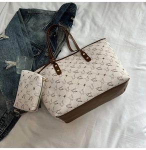 Detail of a beige tote bag set with brown swan pattern and matching zipper pouch