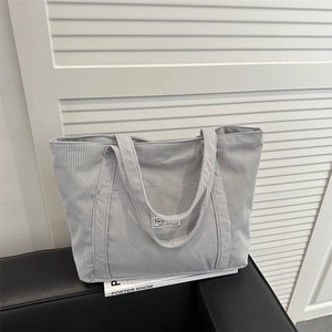 Light gray corduroy tote bag with Fashion Instinct label on a minimal sofa