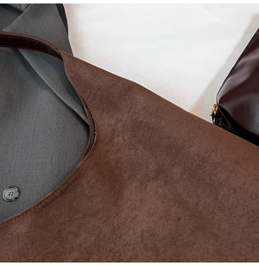 Detailed close-up of dark brown suede tote bag with precise stitching and matte leather texture