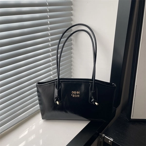 Glossy black patent leather shoulder bag with metallic lettering and knotted straps